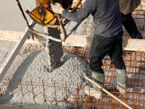 Proces wylewania betonu na konstrukcję.